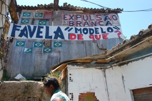As frases "Favela Modelo De Que?" e "Expulsão Branca" na faixa de um barraco do Santa Marta mostram a insatisfação de moradores. Foto: Miriane Peregrino