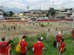Turistas assistem partida de futebol em campo de várzea no Complexo do Alemão (Foto: Mariluce Mariá.)